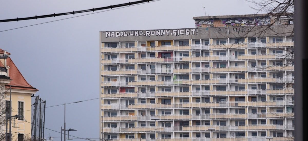 A graffiti saying "Naddle und Ronny siegt" on top of an old gdr building.